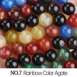 May include: A collection of round, colorful agate beads in various shades of red, blue, green, yellow, and black. The beads are smooth and polished, and they are arranged in a random pattern.  NO.7 Rainbow Color Agate