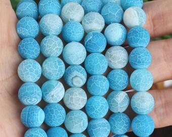 May include: A strand of blue agate beads with a white crackle pattern. The beads are round and have a smooth, polished finish.