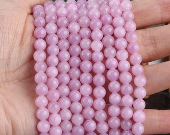 Puede incluir: Una hebra de cuentas de piedras preciosas de color rosa pálido. Las cuentas son redondas y lisas, y tienen una apariencia ligeramente translúcida.