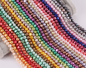 May include: A strand of assorted freshwater pearls in various colors, including white, pink, green, blue, and purple. The pearls are irregular in shape and have a smooth, polished finish.