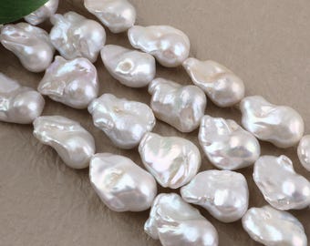 May include: A strand of white baroque pearls with irregular, organic shapes and a high-luster, iridescent finish. Each pearl displays unique ridges and smooth, rounded surfaces, creating a textured appearance across the entire length.