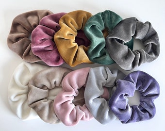 Può includere: Assortimento di dieci scrunchies in velluto di vari colori, tra cui grigio, viola, rosa, beige, bianco, verde, marrone e oro.
