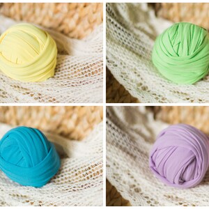 May include: Four balls of fabric in different colors: yellow, green, blue, and purple. The balls are made of soft, stretchy fabric and are perfect for newborn photography props.