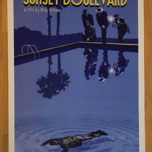 May include: A vintage movie poster for the film "Sunset Boulevard" featuring a blue pool with a silhouette of a dog floating in the water. The poster also features the names of the actors Gloria Swanson, William Holden, Erich Von Stroheim, and Nancy Olson, and the text "a film by Billy Wilder".