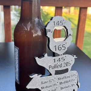 May include: A metal cow-shaped bottle opener with a built-in thermometer. The thermometer has markings for different temperatures for cooking meat, including rare, medium rare, medium, medium well, well, and pulled pork. The bottle opener is silver and has a textured surface.