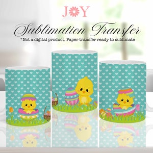 May include: Three white ceramic mugs with a sublimation transfer design featuring a yellow chick with colorful Easter eggs on a turquoise background with white hearts. The text "Sublimation Transfer" is printed on the top of the image.