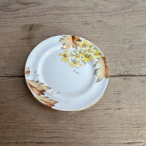 ヴィンテージのトスカーナ植物花柄ボーンチャイナ製小ピン皿。白地に黄