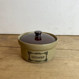 May include: A brown and beige ceramic jar with a lid. The jar has a black label with the text "UIENSOEP" in a decorative font.