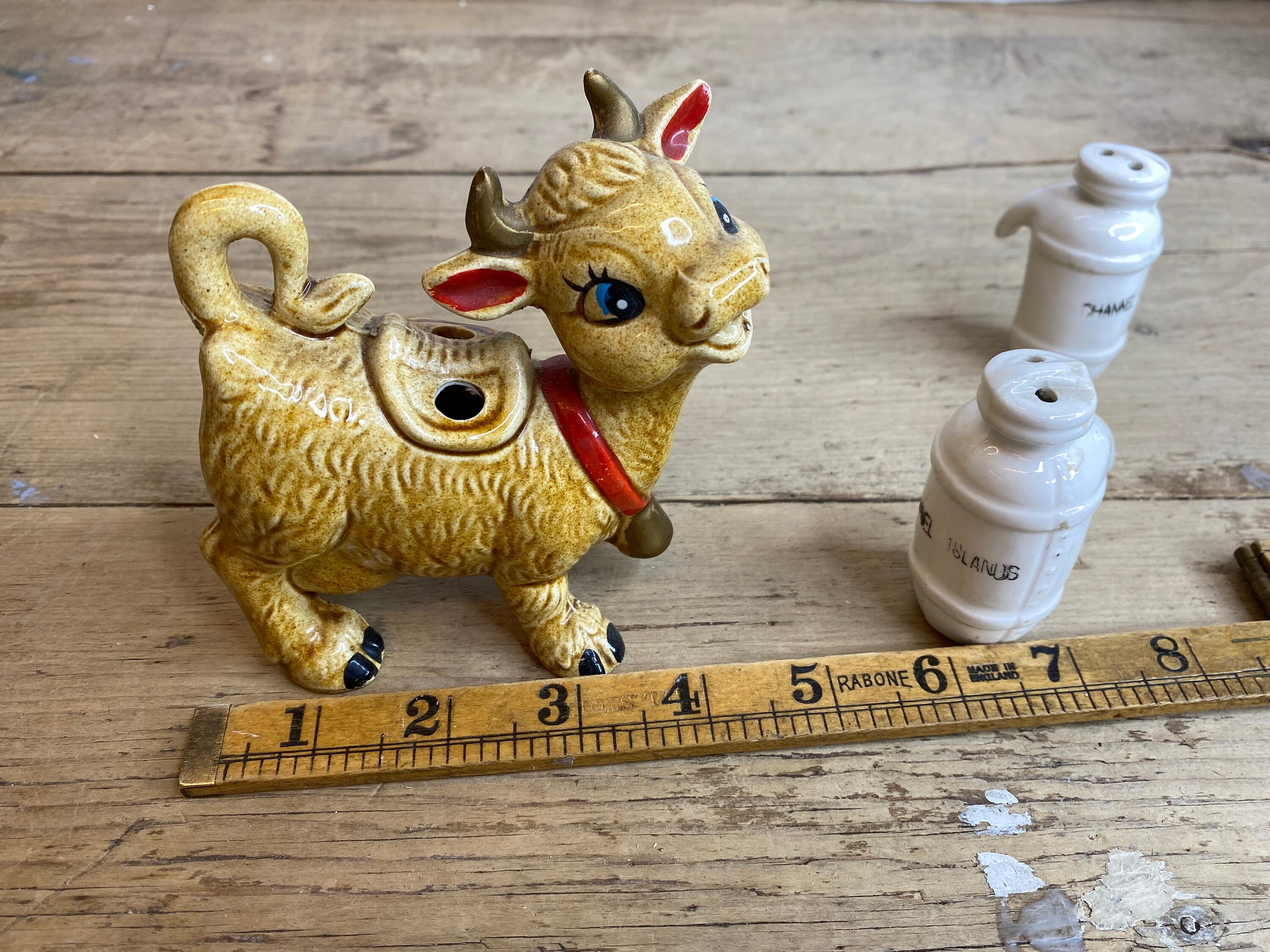 ビンテージの茶色の牛の置物、ベル付き。側面に塩コショウ入れが付い