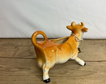 ビンテージの茶色と白のジャージー牛の置物、ベル付き。かわいい