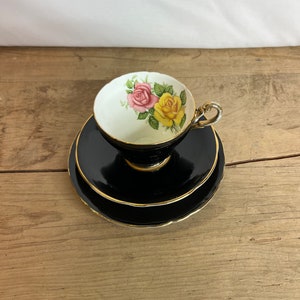 Vintage Unnamed Black and White Trio - Tea Cup, Saucer and Side Plate with Gilt Edge and Pink Yellow Roses Inside the Cup. In Good Condition