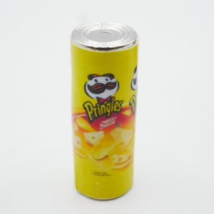 Pu&ograve; includere: Una lattina gialla di patatine Pringles al sapore di formaggio e panna acida. La lattina ha un logo rosso e bianco con un personaggio dei cartoni animati con i baffi e un cappello rosso. La lattina &egrave; su uno sfondo bianco.