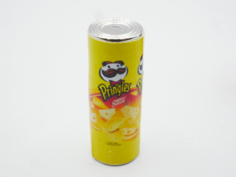 Pu&ograve; includere: Una lattina gialla di patatine Pringles al sapore di formaggio e panna acida. La lattina ha un logo rosso e bianco con un personaggio dei cartoni animati con i baffi e un cappello rosso. La lattina &egrave; su uno sfondo bianco.