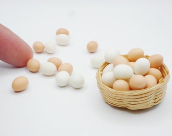 May include: A small wicker basket filled with white and brown eggs. The basket is sitting on a white surface. There are several loose eggs scattered around the basket.
