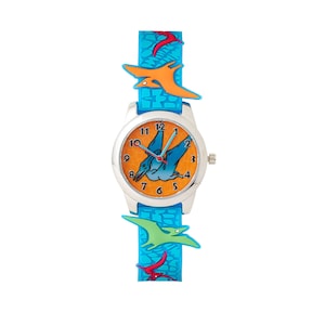 Puede incluir: Un reloj para niños azul y naranja con un diseño de dinosaurio en la esfera y una correa azul con gráficos de dinosaurios. El reloj tiene una caja plateada y manecillas blancas.