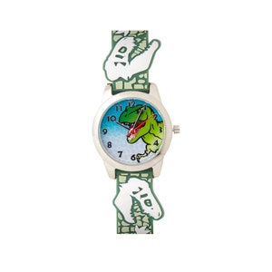 Puede incluir: Un reloj de dinosaurio verde y blanco con una esfera plateada. La esfera del reloj tiene un dinosaurio verde con ojos rojos y un fondo azul y blanco. Los números en la esfera del reloj son negros.