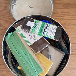 Vintage tin of sewing supplies and notions