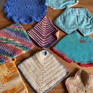 May include: A collection of handmade crochet and fabric pot holders in various shapes and colors. Includes a blue circular pot holder, a rainbow striped one, and several square and hexagonal designs. Some have decorative edges.