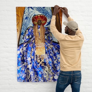 May include: A colorful religious icon print featuring a figure in a blue and gold patterned robe with a red crown. The figure is standing in front of a blue and white background.