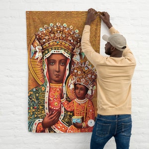 Könnte beinhalten: Eine Wandteppich mit einem religiösen Bild der Jungfrau Maria und dem Jesuskind. Die Jungfrau Maria ist mit einem dunklen Teint und einer goldenen Krone dargestellt. Sie trägt ein blaues Gewand mit goldener Stickerei und einen roten Umhang. Das Jesuskind trägt ein rot-goldenes Gewand und hält eine goldene Kugel. Der Hintergrund ist gold-braun.