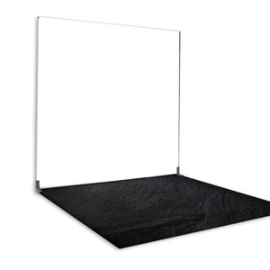 Puede incluir: Un telón de fondo blanco con un suelo negro texturizado. El telón de fondo está hecho de un material delgado y transparente y está sostenido por un marco de metal.