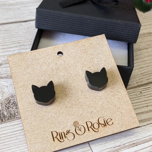 May include: A pair of black cat silhouette stud earrings displayed on a brown card with the text "Ring & Rosie".