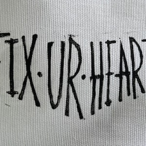 May include: Black and white text on a white canvas background that reads "FIX.UR.HEART".