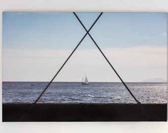 Sail boat on a sea between two industrial cables