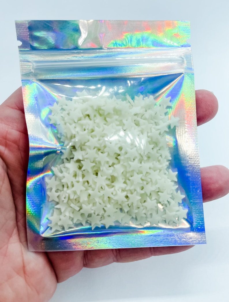 May include: A small iridescent resealable bag filled with white glow-in-the-dark star sprinkles.
