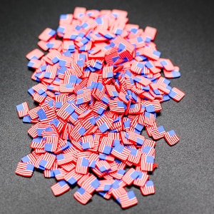 May include: A large pile of small, red, white, and blue American flags.