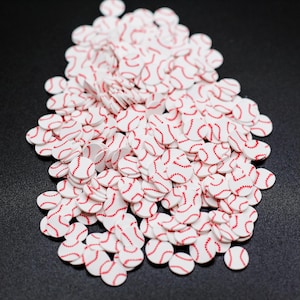 May include: A large pile of white and red baseball-themed confetti. The confetti is in the shape of circles with red stitching around the edges.