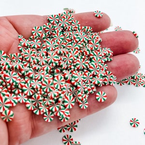 May include: A large pile of red, white, and green candy cane sprinkles. The sprinkles are in the shape of a candy cane and are perfect for decorating cakes, cookies, and other desserts.