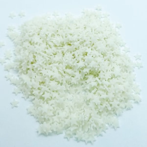 May include: A pile of white star-shaped sprinkles.