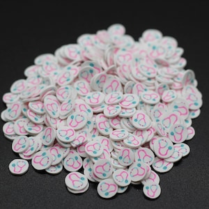 May include: A large pile of white round sprinkles with a pink and blue stethoscope design.