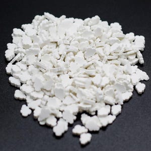 May include: A pile of white cloud-shaped sprinkles. The sprinkles are small and have a slightly textured surface.