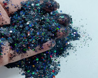 May include: Black glitter with iridescent and holographic accents. The glitter is a mix of small and large pieces.