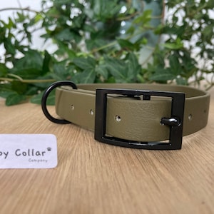 May include: A green rubber dog collar with a black buckle and a D-ring. The collar is textured and has the text "The Happy Collar Company" on a white label.