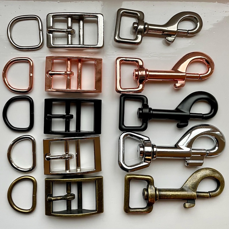 May include: Assortment of silver, gold, and black metal dog leash hardware, including D-rings, buckles, and clasps.
