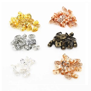 May include: An assortment of earring backs in various metallic finishes, including gold, copper, silver, bronze, and rose gold. The earring backs are butterfly style, with a post insert and a secure clasp. The image is taken on a white background.