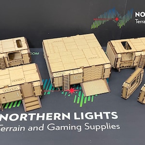 May include: A set of five wooden modular building pieces for tabletop gaming. The pieces are unpainted and feature a futuristic design with details like ladders and doors. The pieces are labeled with numbers 1, 2, and 10. The set is from Northern Lights Terrain and Gaming Supplies.