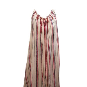 Puede incluir: Vestido largo y fluido con rayas verticales crema, azul marino y rojo. Cuenta con tirantes finos y un escote fruncido con borlas decorativas. La tela es ligera, ideal para climas c&aacute;lidos.