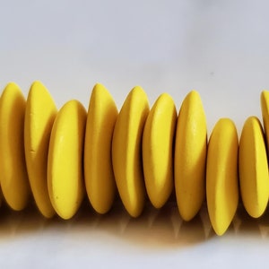 May include: A row of 20 bright yellow oval-shaped beads. The beads are smooth and have a matte finish.