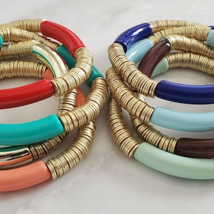 May include: Two sets of colorful bracelets with gold accents. Each set has four bracelets with different colored bands and gold chain links. The colors include red, turquoise, coral, blue, light blue, and green.