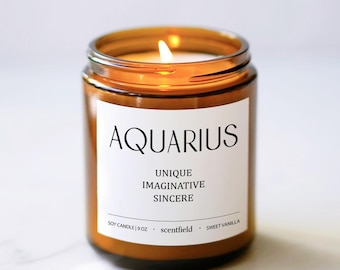 May include: A brown glass candle jar with a white label that reads "AQUARIUS UNIQUE IMAGINATIVE SINCERE SOY CANDLE | 9OZ. scentfield SWEET VANILLA".