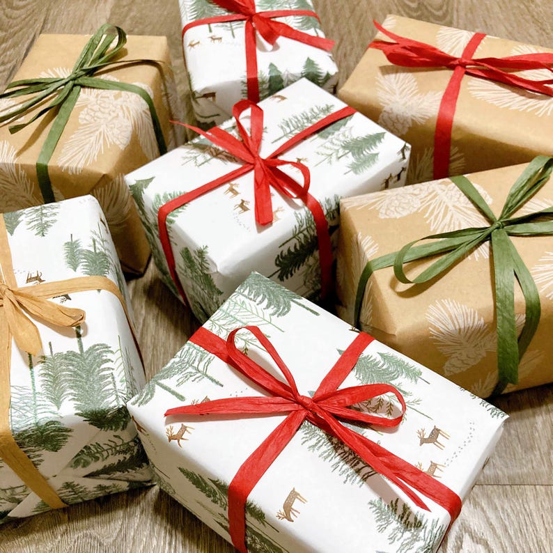 May include: Six wrapped gifts with various patterns and colors. The gifts are wrapped in brown paper with white pine tree designs, white paper with green pine tree designs, and white paper with red and green pine tree designs. The gifts are tied with green, red, and brown ribbon.