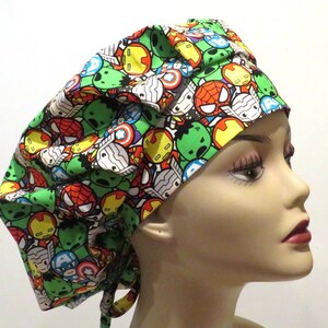 Puede incluir:  gorro de quirófano verde, rojo, amarillo y azul con un patrón de caras de superhéroes de dibujos animados.