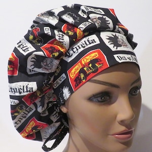 Puede incluir: Un gorro de exfoliación bouffant negro con un patrón repetido de Cruella De Vil, su nombre y las palabras "Devil" y "Spell Demon" en rojo y blanco. El gorro es de tela y tiene un cierre de lazo.