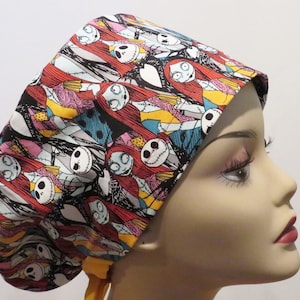 May include: A colourful surgical scrub hat with a repeating pattern of Jack Skellington and Sally from the Nightmare Before Christmas film. The hat has a yellow tie.