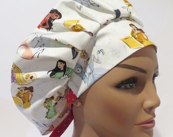 May include: White surgical scrub hat with a red and white tie. The hat features a print of Disney princesses, including Cinderella, Belle, Rapunzel, and Mulan.