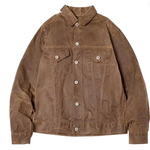 May include: A brown waxed cotton jacket featuring a classic collar, two chest pockets, and button fastenings. The jacket has a slightly worn appearance, suggesting a vintage or rugged style. The jacket is a versatile outerwear piece.